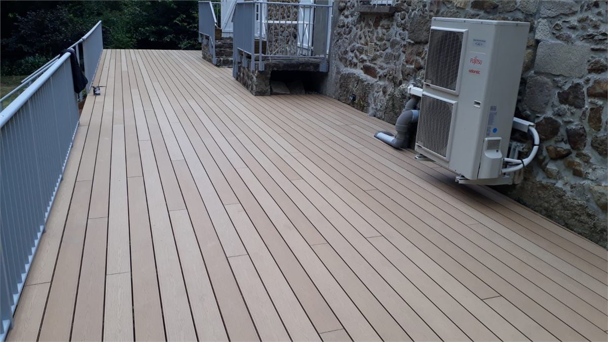 Terrasse composite contre un mur en pierre